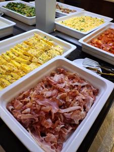 a table topped with trays of different types of food at Skyna Hotel Luanda in Luanda