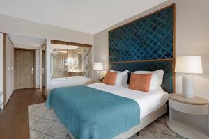 a bedroom with a large bed with a blue headboard at Cascade Wellness Resort in Lagos