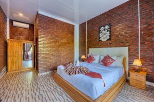 a bedroom with a bed and a brick wall at Dyou Villa in Nusa Penida +33 photos