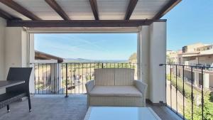 a patio with a chair and a balcony with a view at Appartamento La Vigna 3 in Badesi