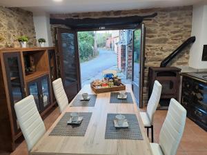a dining room with a wooden table with white chairs at CASA ARABIA in Monforte de Lemos