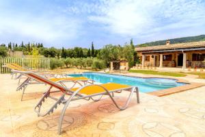 einen Pool mit Liegestühlen und ein Haus in der Unterkunft Maravillosa casa Ses Comes con piscina in Selva