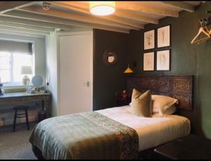 a bedroom with a bed and a desk in it at The Bridge House in Bridport
