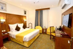 a hotel room with a bed and a flat screen tv at Rose Jeddah Hotel in Jeddah
