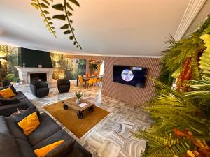 uma sala de estar com um sofá e uma televisão em Villa avec pièce Billard style Ranch US em Saint-Fargeau-Ponthierry