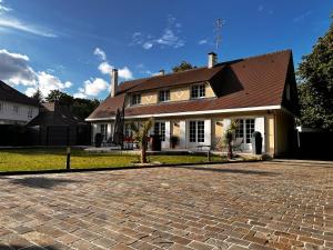 uma casa com uma entrada de tijolos em frente em Villa avec pièce Billard style Ranch US em Saint-Fargeau-Ponthierry