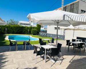 eine Terrasse mit Tischen und Stühlen und einem Pool in der Unterkunft Hotel Ignacio - PalomarGroup in Chiva