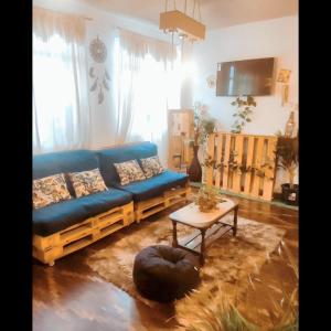 ein Wohnzimmer mit einem blauen Sofa und einem Tisch in der Unterkunft Irania House - Hermoso departamento con estilo diferente in Loja
