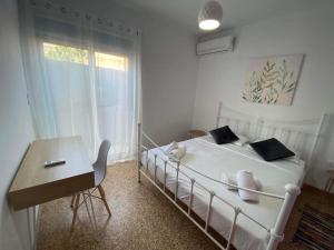 a bedroom with a bed and a table and a desk at NEW! Flower Patio House 2 BDR - BBQ - Wash machine in Lavrio