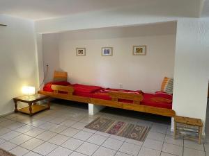 - un salon avec un canapé rouge long et une table dans l'établissement Idyllische Ferienwohnung zwischen Meer und See, à Punta del Este