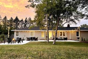 a house with a table and chairs in the yard at HOT TUB - Grand Haven/Spring Lake Waterfront Home in Spring Lake