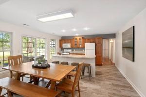 a kitchen and dining room with a table and chairs at HOT TUB - Grand Haven/Spring Lake Waterfront Home in Spring Lake +31 photos