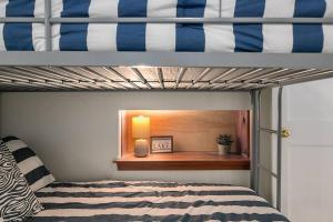 Dormitorio con litera, lámpara y ventana en HOT TUB - Grand Haven/Spring Lake Waterfront Home, en Spring Lake