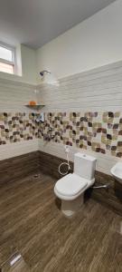 a bathroom with a toilet and a sink at Magnolia Villa Luxury 3 Bedroom Apartments in Visakhapatnam +6 photos