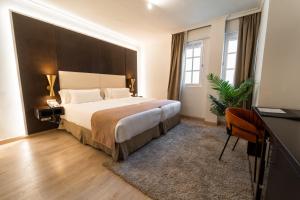 a bedroom with a large bed with a large headboard at Hotel Taburiente S.C.Tenerife in Santa Cruz de Tenerife