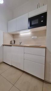 a kitchen with white cabinets and a microwave at Finnem Rentals Kyjevská in Prague