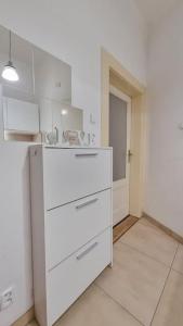 a kitchen with white cabinets and a white floor at Finnem Rentals Kyjevská in Prague