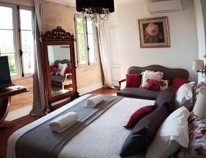 a bedroom with a large bed and a mirror at Le Clos Réaud in Blaye