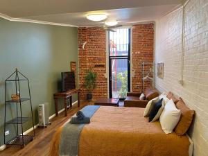 a bedroom with a bed and a brick wall at The Wool Store in Bathurst