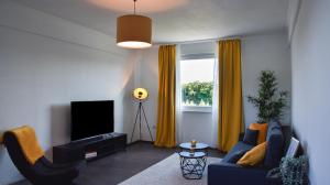 ein Wohnzimmer mit einem blauen Sofa und einem TV in der Unterkunft Deluxe! Hbf-Nähe mit Kingsize-Bett, 65 m2 in Duisburg