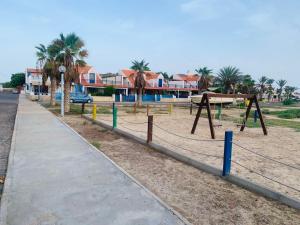 a park with a swing set and a sidewalk at Casa Mar e Sol - Murdeira - Ilha do Sal in Palha Verde