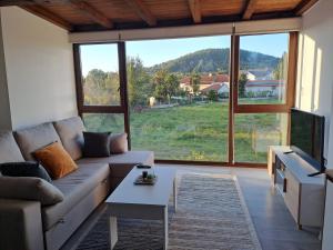 a living room with a couch and a large window at CASA ARABIA in Monforte de Lemos