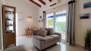 een woonkamer met een bank en een tafel bij Apartamento en el campo de golf Son Parc, Menorca in Son Parc