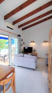 sala de estar con sofá blanco y TV en Apartamento en el campo de golf Son Parc, Menorca, en Son Parc