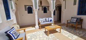 a living room with two chairs and a table at Beit El Ezz - la grande in Ouled Yaneg