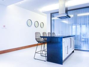 a kitchen with a blue counter and chairs at Beachfront 2br 2bath apartment private plunge pool 50 meter to Naithon beach in Nai Thon Beach +24 photos