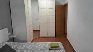 um quarto com armários brancos e uma cama com uma almofada verde em Apartamento Molino em Almeria