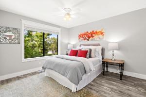 a white bedroom with a bed and a window at Condo Serenity in Charleston