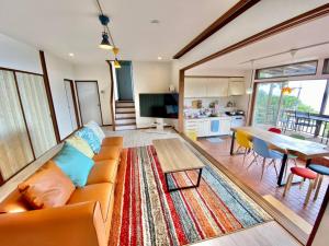 a living room with a couch and a table at 露天風呂オーシャンビューBlue Ocean IZU in Ajiro