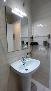 y baño con lavabo blanco y espejo. en Apartamento en el campo de golf Son Parc, Menorca, en Son Parc