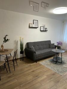 a living room with a couch and a table at luksio 14 in Kėdainiai