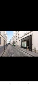 an empty street with buildings and a cobblestone road at IMHOST - Amazing architect studio Père Lachaise in Paris