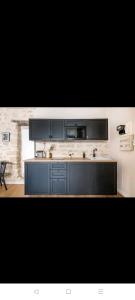 a kitchen with black cabinets and a counter top at IMHOST - Amazing architect studio Père Lachaise in Paris