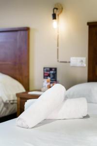 una pila de toallas sentadas encima de una cama en AS HOTELES FUENTE LA HIGUERA direccion Albacete, en Fuente la Higuera