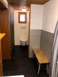 a bathroom with a toilet and a wooden bench at Haus Huber in Bad Hindelang