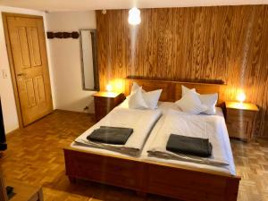 a bedroom with a large bed with two pillows on it at Haus Huber in Bad Hindelang