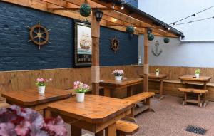 a restaurant with wooden tables and flowers on the wall at The White Bear Hotel in Bedale