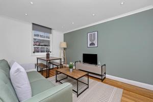 a living room with a couch and a tv at The Old Street Apartment in London