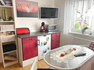 ケルピンセにあるFerienwohnung Loddin USE 2801のキッチン(赤い冷蔵庫、テーブル付)