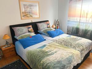ケルピンセにあるFerienwohnung Loddin USE 2801のベッドルーム1室(青い枕のベッド1台付)