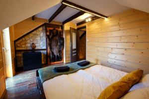 sypialnia z łóżkiem w pokoju z drewnianymi ścianami w obiekcie Przystanek Madejowa w mieście Jeleśnia