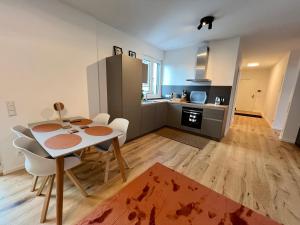 uma cozinha e sala de jantar com mesa e cadeiras em Workplace Apt/27inch Screen for 2 or 4/Kitchen em Offenbach