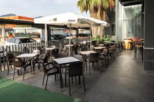 un restaurante al aire libre con mesas, sillas y sombrillas en AS HOTELES FUENTE LA HIGUERA direccion Albacete, en Fuente la Higuera