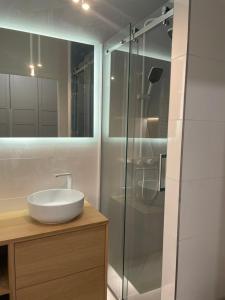 a bathroom with a sink and a glass shower at LeHome Airport Wroclaw in Wrocław