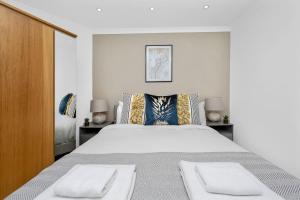 una camera bianca con un grande letto con due comodini di The Old Street Apartment a Londra