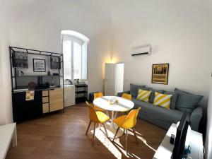 a living room with a couch and a table and yellow chairs at Liberty Villa 2 in Bari